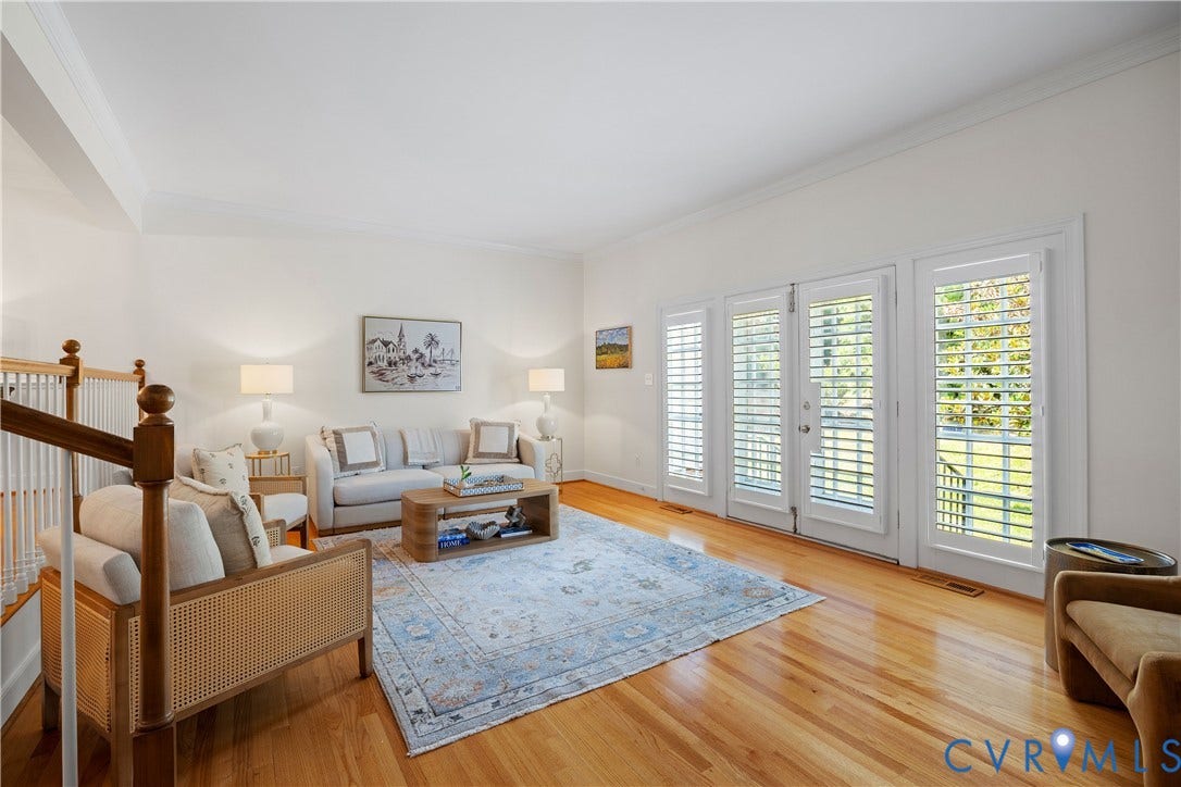 300 N Ridge Road, #97, Henrico, VA 23229 Hardwood flooring, white wall paint, crown molding, white plantation shutters, and a white wood staircase with wood handrails