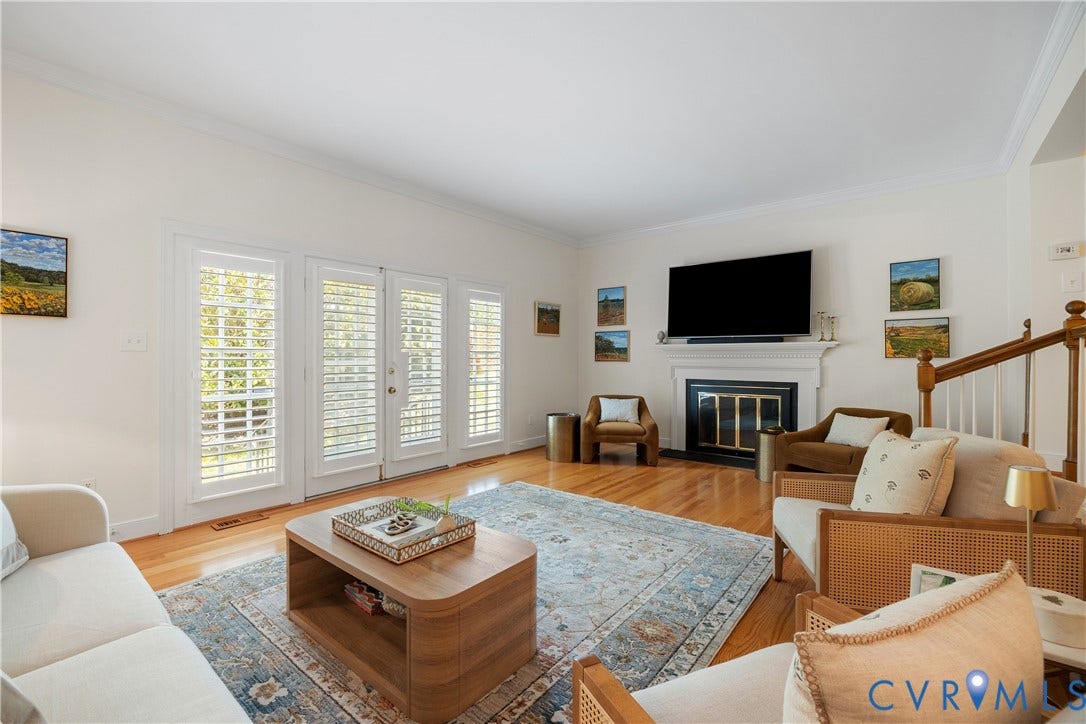 300 N Ridge Road, #97, Henrico, VA 23229 Hardwood flooring, white fireplace mantel, French doors with plantation shutters, white crown molding, and a wood staircase