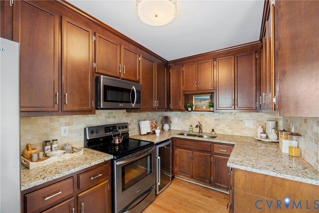 300 N Ridge Road, #97, Henrico, VA 23229 Updated kitchen features hardwood floors, wood cabinetry with crown molding, stainless appliances, granite countertops, and a tiled backsplash