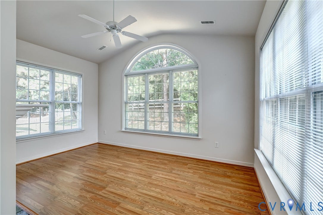 5046 Lewisetta Drive, Carriage Homes II Crossridge, Glen Allen, VA 23060 Wood-finish flooring, vaulted ceiling, arched window, ceiling fan, and multiple windows with blinds