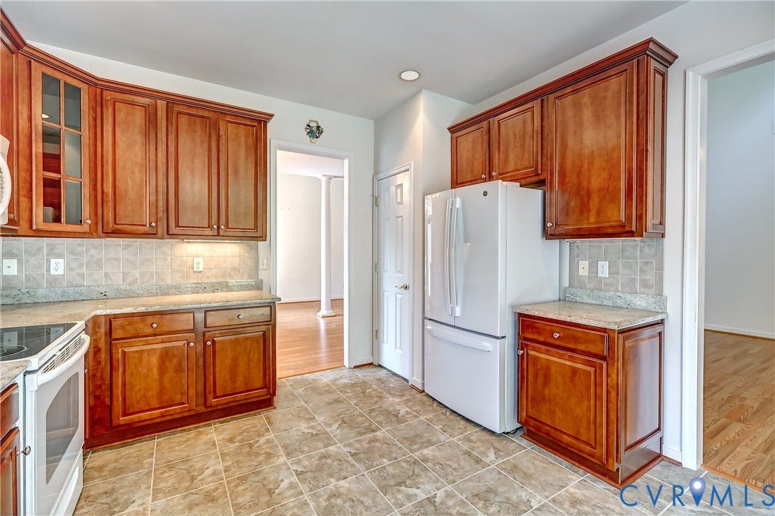 5046 Lewisetta Drive, Carriage Homes II Crossridge, Glen Allen, VA 23060 Kitchen featuring wood cabinetry, tiled flooring, speckled countertops, and a tiled backsplash