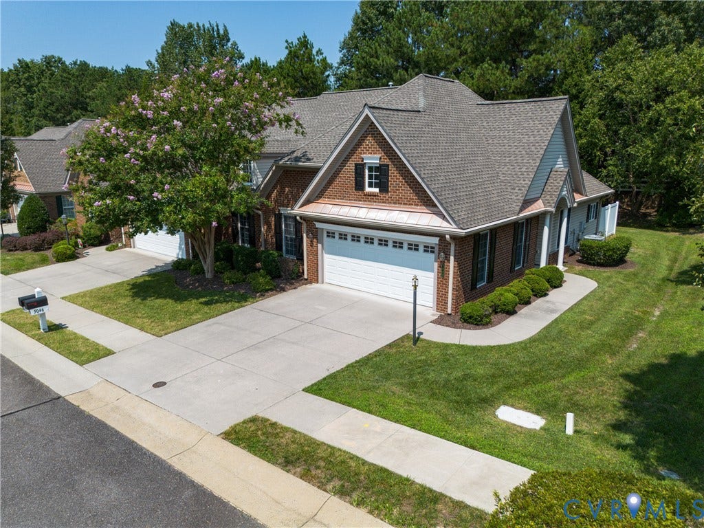 5046 Lewisetta Drive, Carriage Homes II Crossridge, Glen Allen, VA 23060 Brick exterior with white siding accents, architectural shingle roof, attached two-car garage, concrete driveway, and established landscaping