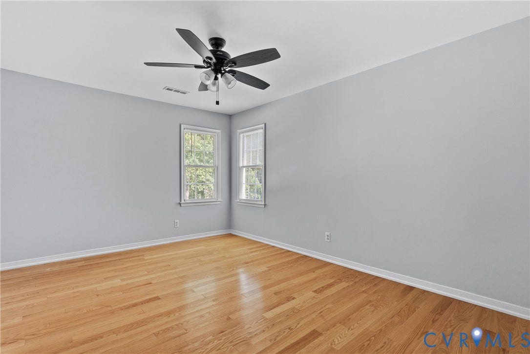 3242 Sherwood Ridge Drive, Powhatan, VA 23139 Wood-finish flooring, light gray walls, two windows, and a ceiling fan with integrated lighting