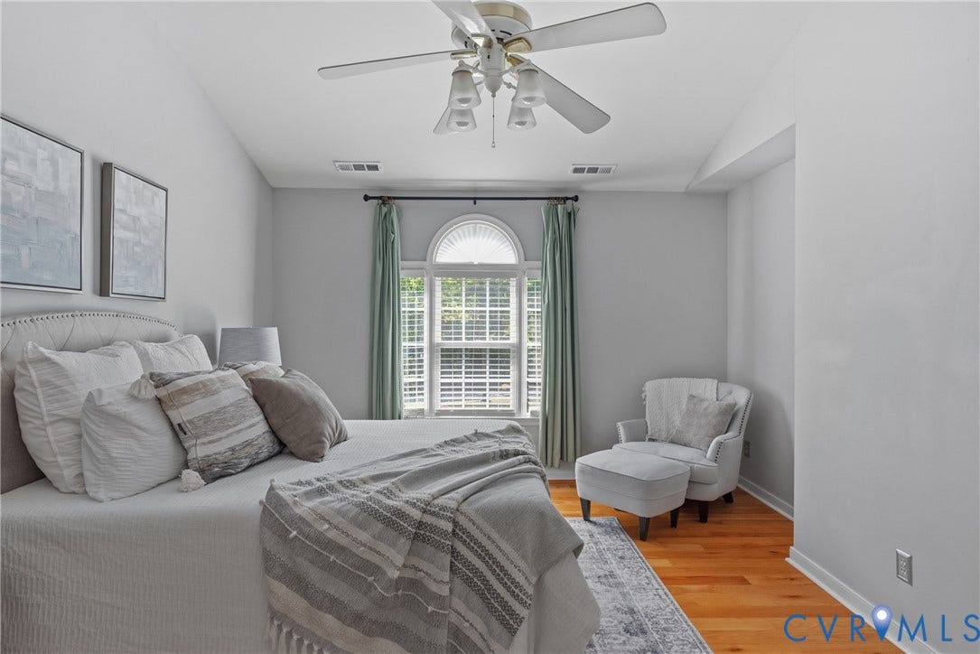 3242 Sherwood Ridge Drive, Powhatan, VA 23139 Vaulted ceiling with a ceiling fan, arched window with white louvered shutters, light wood-finish flooring, and white wall trim