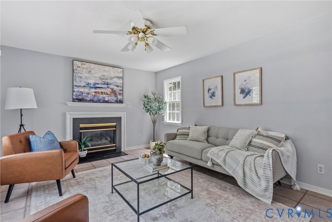 3242 Sherwood Ridge Drive, Powhatan, VA 23139 Living room featuring a fireplace with a black surround and white mantel, a ceiling fan, and light-toned wall finishes