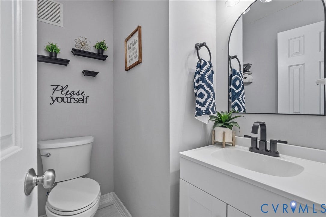 3242 Sherwood Ridge Drive, Powhatan, VA 23139 Modern vanity with white countertop, black faucet, and arched mirror
