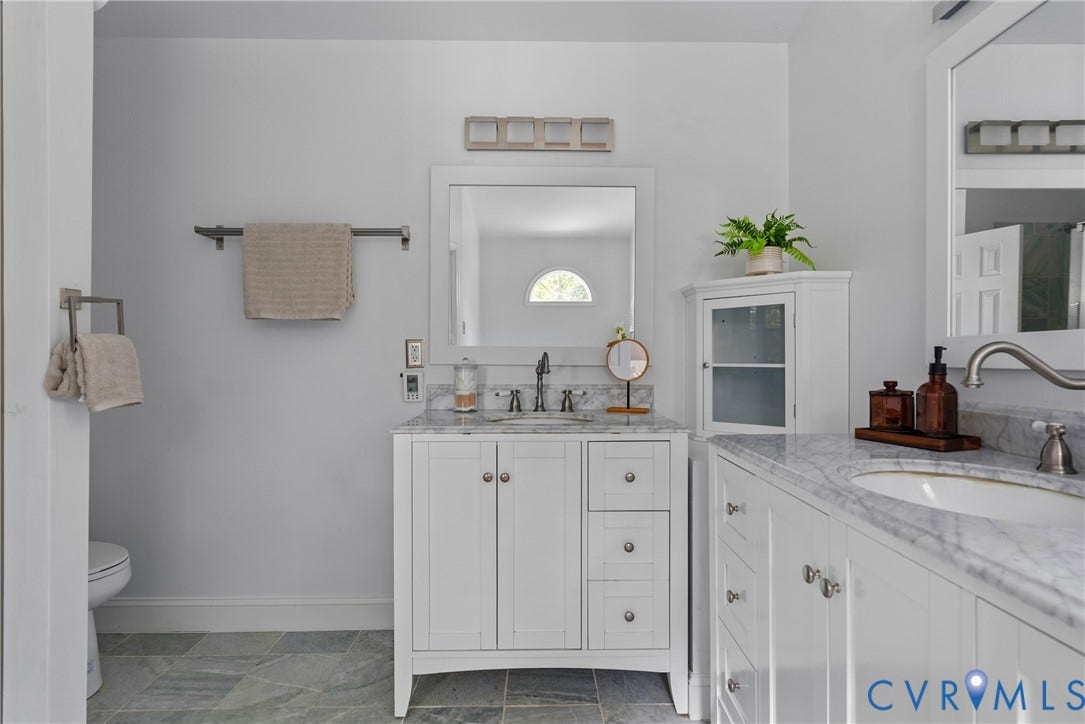 3242 Sherwood Ridge Drive, Powhatan, VA 23139 Dual white vanities with integrated sinks, each topped with a stone-finish countertop