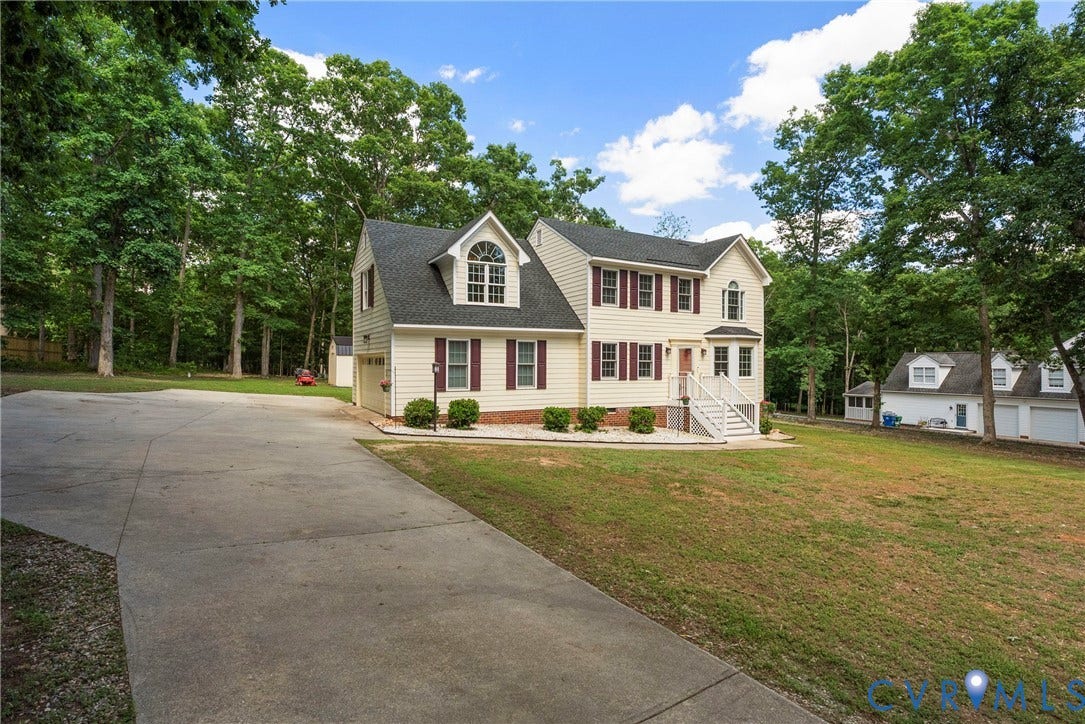 3242 Sherwood Ridge Drive, Powhatan, VA 23139 Two-story residence with light-colored siding, dark shutters, and a prominent dormer window