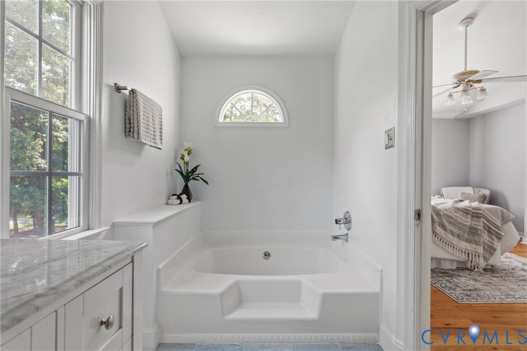 3242 Sherwood Ridge Drive, Powhatan, VA 23139 Integrated soaking tub with chrome fixtures, arched transom window, and a double-hung window