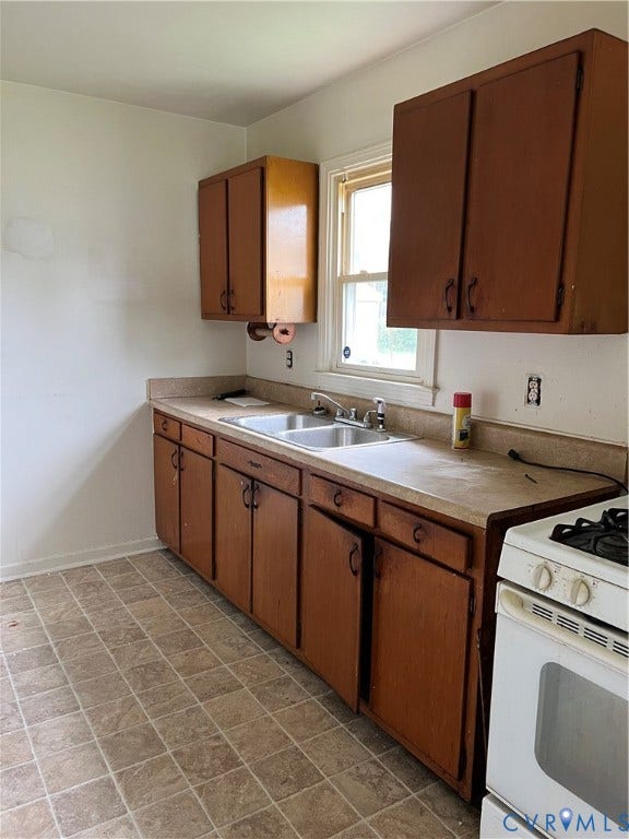 5429 Blueridge Avenue, Fulton, Richmond, VA 23231 Kitchen featuring wood-finish cabinetry, a double basin stainless steel sink, a window, and tile flooring