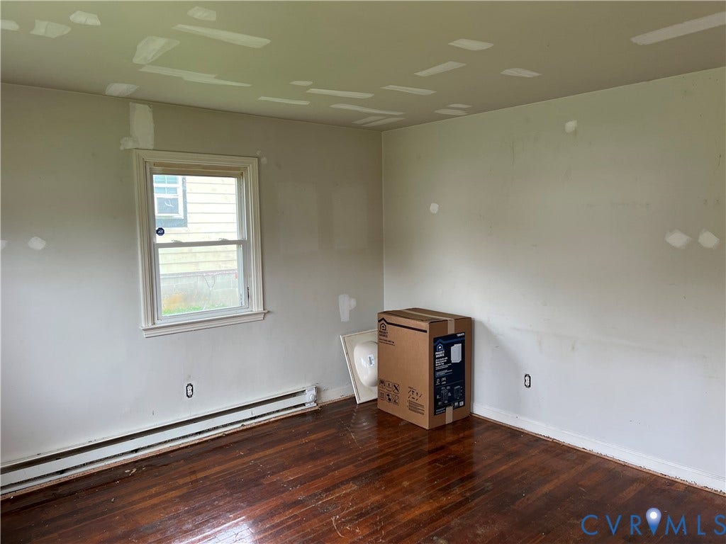 5429 Blueridge Avenue, Fulton, Richmond, VA 23231 Hardwood flooring, painted walls with visible repairs, single window with white trim, baseboard heating unit
