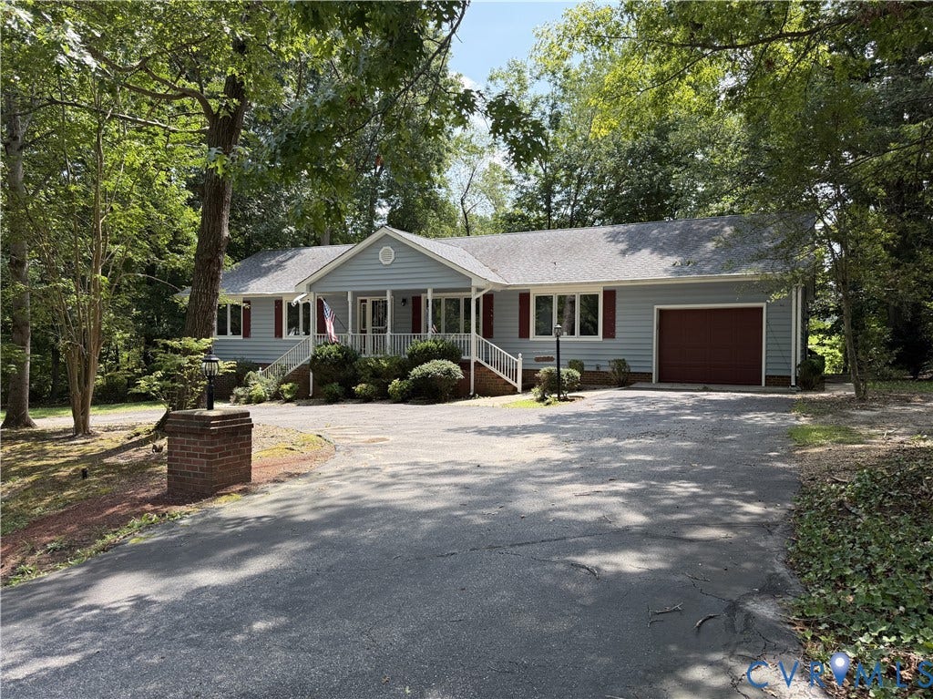 4603 Edenton Place, Greenbriar, Chester, VA 23831 Ranch-style residence featuring light blue siding, a covered front porch, an attached garage with a reddish-brown door, and a paved driveway