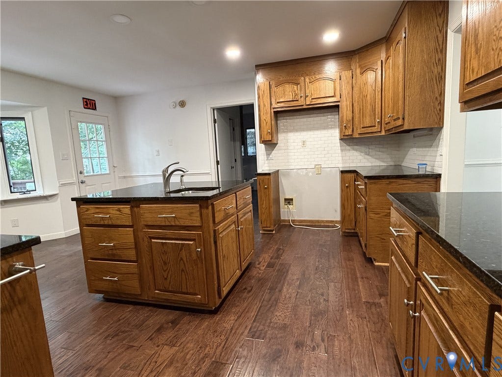 4603 Edenton Place, Greenbriar, Chester, VA 23831 Spacious kitchen featuring warm wood cabinetry, a large center island with ample countertop space, stainless steel appliances, subway tile backsplash, and wood-finish flooring throughout the open layout