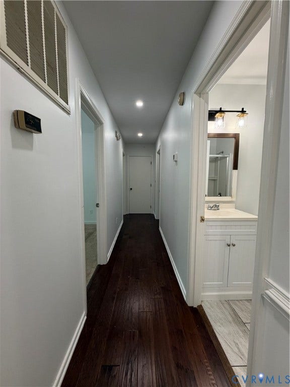 4603 Edenton Place, Greenbriar, Chester, VA 23831 Dark wood-finish flooring with recessed ceiling lighting, a bathroom featuring a white vanity with a light-toned countertop, and a wood-framed mirror with a three-light fixture