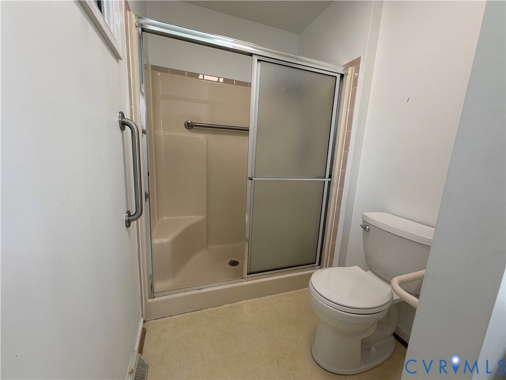 4603 Edenton Place, Greenbriar, Chester, VA 23831 Enclosed shower with sliding frosted glass door, integrated grab bar, and a single-flush toilet with an adjacent support rail