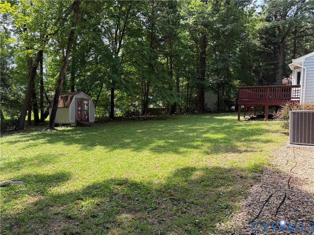 4603 Edenton Place, Greenbriar, Chester, VA 23831 Expansive green lawn with mature trees, featuring a freestanding shed, a wood deck, and a gravel perimeter