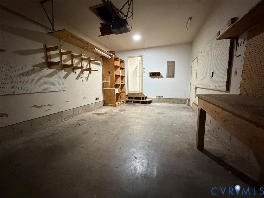 4603 Edenton Place, Greenbriar, Chester, VA 23831 Expansive garage with concrete flooring, built-in shelving, and pegboard panels