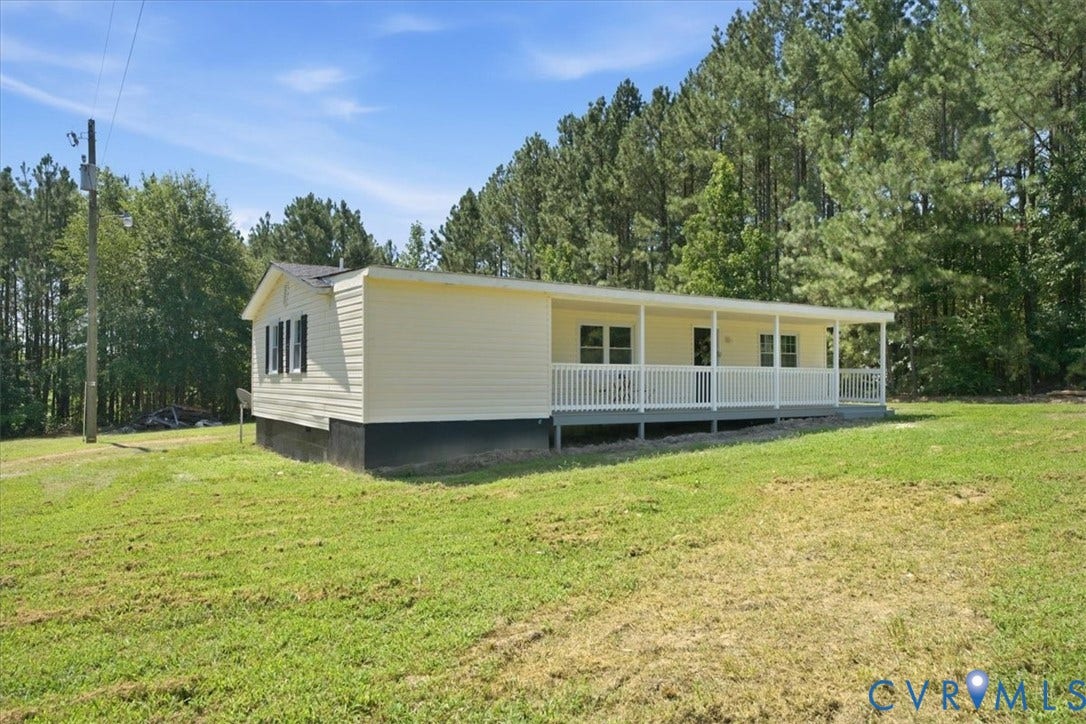 16111 Walkers Mill Road, Stony Creek, VA 23832 Exterior featuring light-colored siding, a full-length covered porch, white railings, and a dark shingled roof