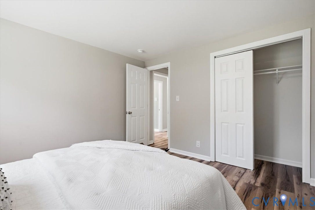 16111 Walkers Mill Road, Stony Creek, VA 23832 Wood-finish flooring, light gray wall paint, and a built-in closet with sliding panel doors