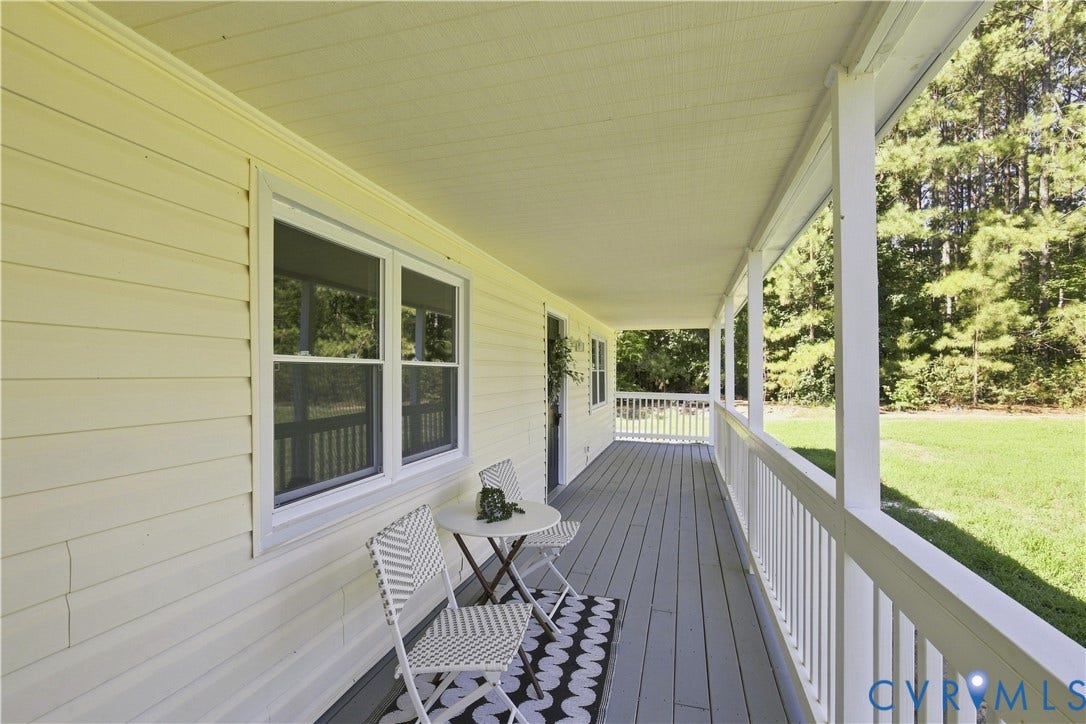 16111 Walkers Mill Road, Stony Creek, VA 23832 Expansive covered porch with white railings, a gray wood-finish floor, and light-colored siding