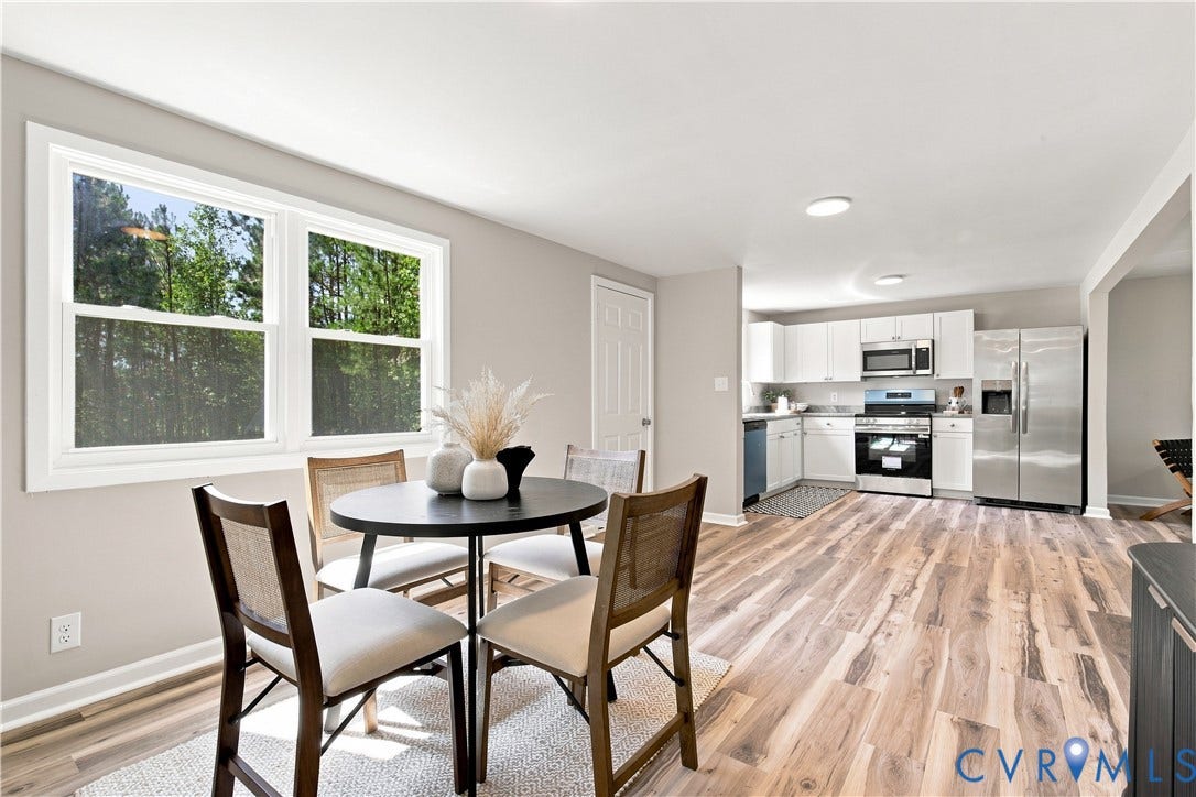 16111 Walkers Mill Road, Stony Creek, VA 23832 Open-concept kitchen and dining area featuring wood-finish flooring, white cabinetry, stainless steel appliances, and a large window