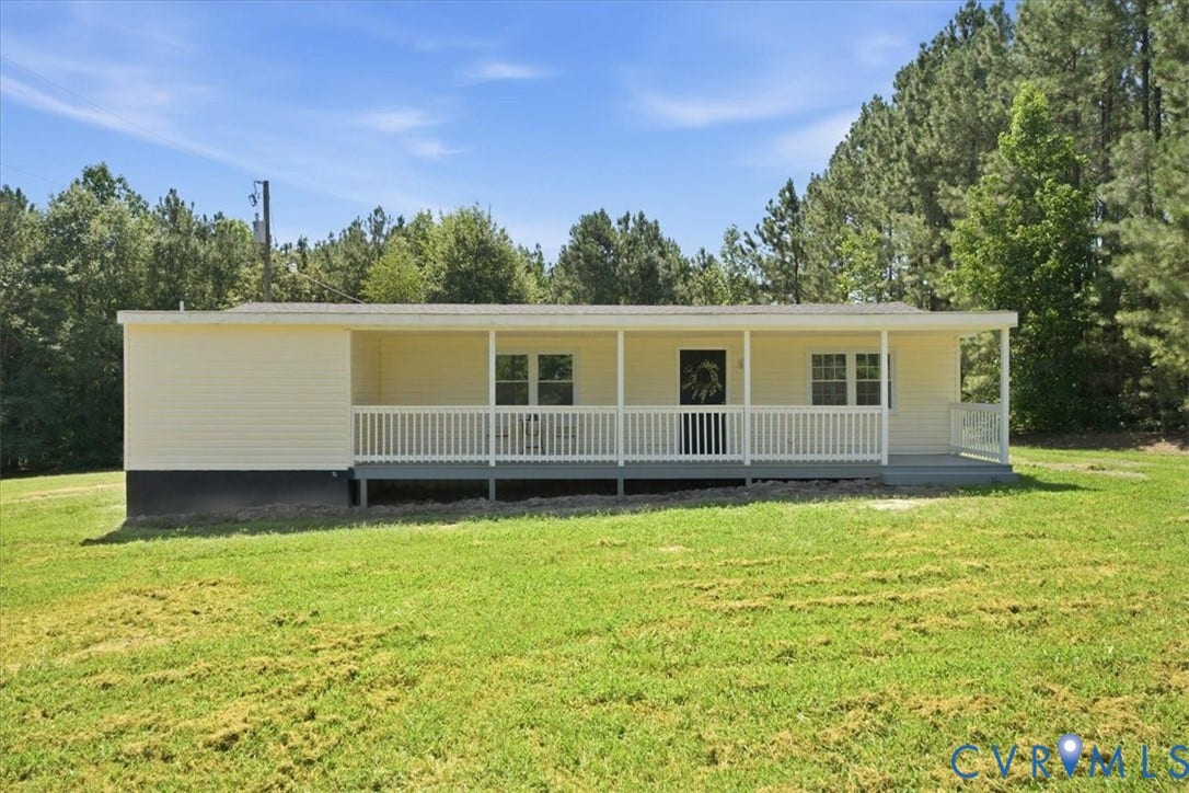 16111 Walkers Mill Road, Stony Creek, VA 23832 Single-story residence featuring light-colored siding, a covered front porch with white railings, and multiple windows