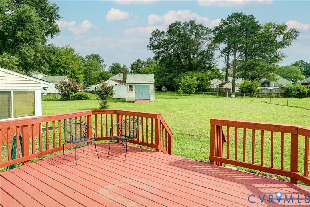 10104 Terry Court, Henrico, VA 23228 Expansive backyard featuring a manicured lawn, mature trees, and a detached storage shed
