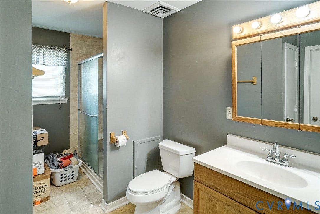 10104 Terry Court, Henrico, VA 23228 White vanity with a single sink, chrome faucet, and wood-finish cabinetry