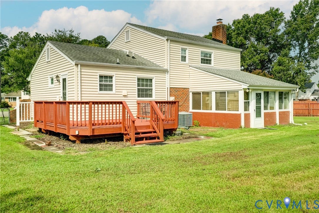 10104 Terry Court, Henrico, VA 23228 Exterior featuring horizontal siding, a red-stained wood deck with stairs, a brick chimney, and an enclosed patio with multiple windows