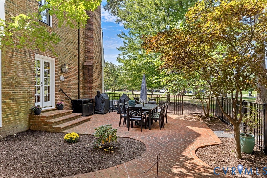 13531 W Salisbury Road, Salisbury, Midlothian, VA 23113 Brick exterior with double French doors, a paver patio, brick steps, and a black wrought iron fence