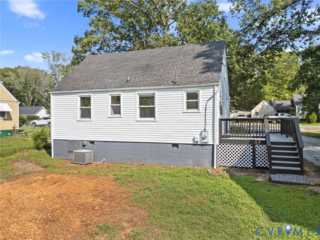 4818 Castlewood Road, Richmond, VA 23234 Charming cottage featuring crisp white horizontal siding, a gabled roofline with architectural shingles, and multiple window openings providing natural light