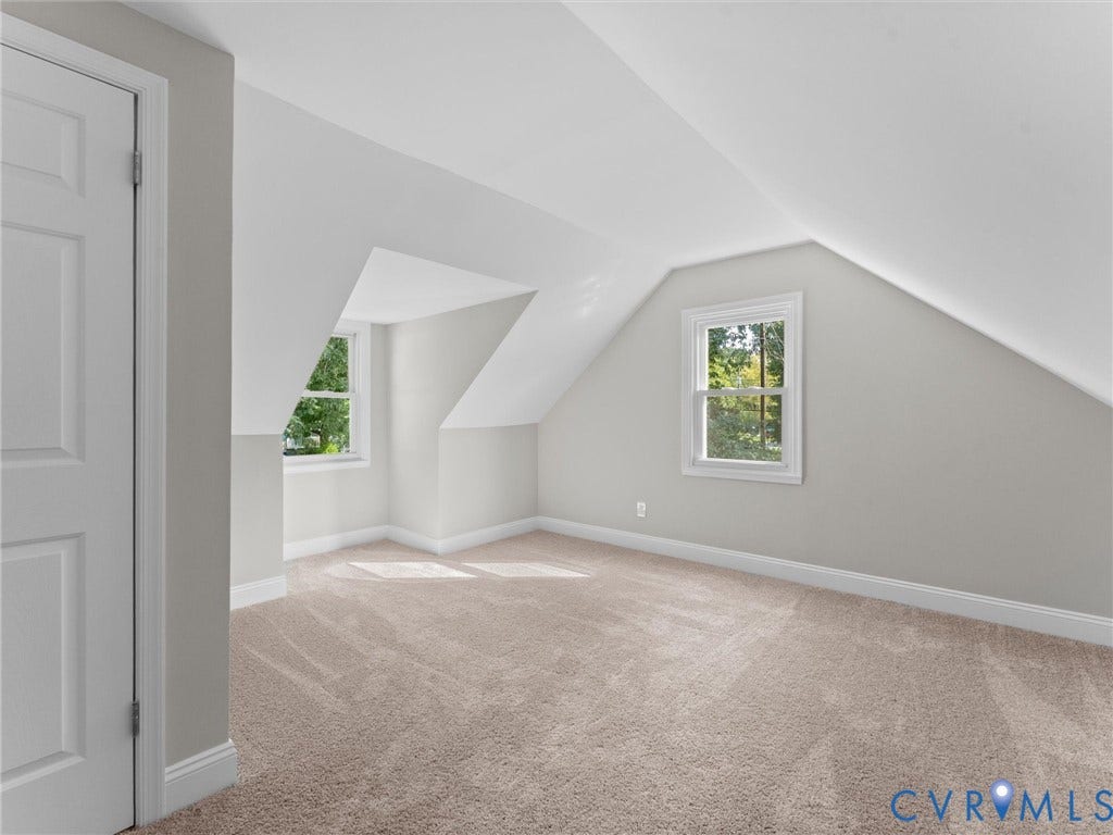 4818 Castlewood Road, Richmond, VA 23234 Bright attic bedroom with sloped ceilings, carpeted flooring, and dual windows providing natural light