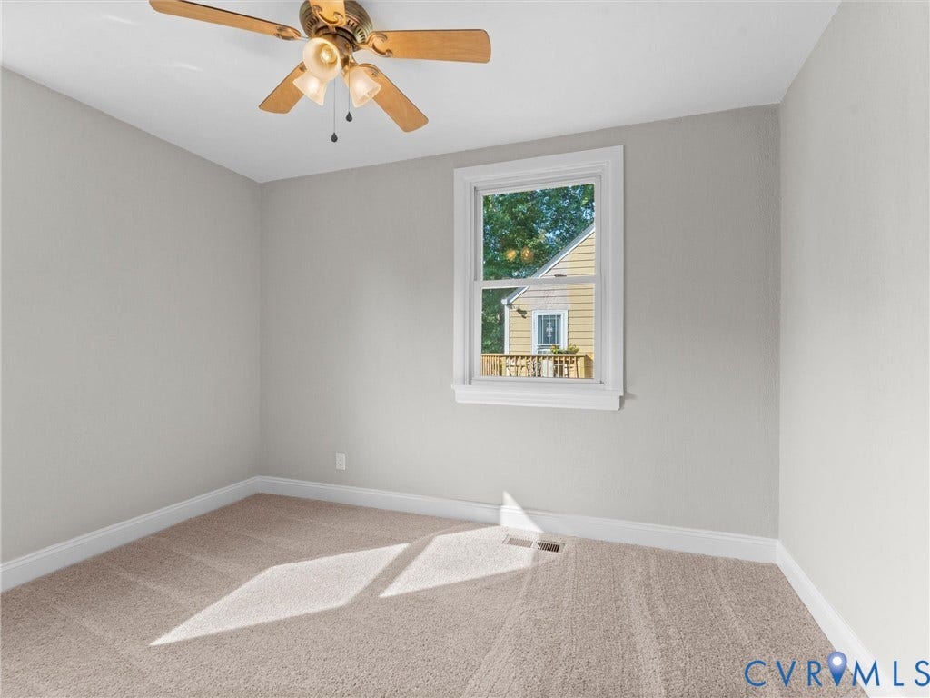 4818 Castlewood Road, Richmond, VA 23234 Bright secondary bedroom featuring neutral wall finishes, carpeting, ceiling fan with integrated lighting, and a picture window framing natural light and outdoor scenery