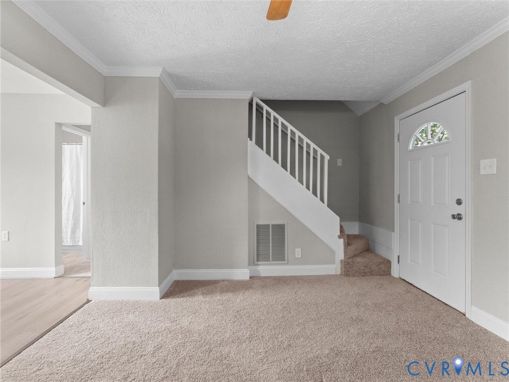 4818 Castlewood Road, Richmond, VA 23234 Welcoming foyer with soaring ceilings, neutral carpeting, and abundant natural light from sidelite entry door