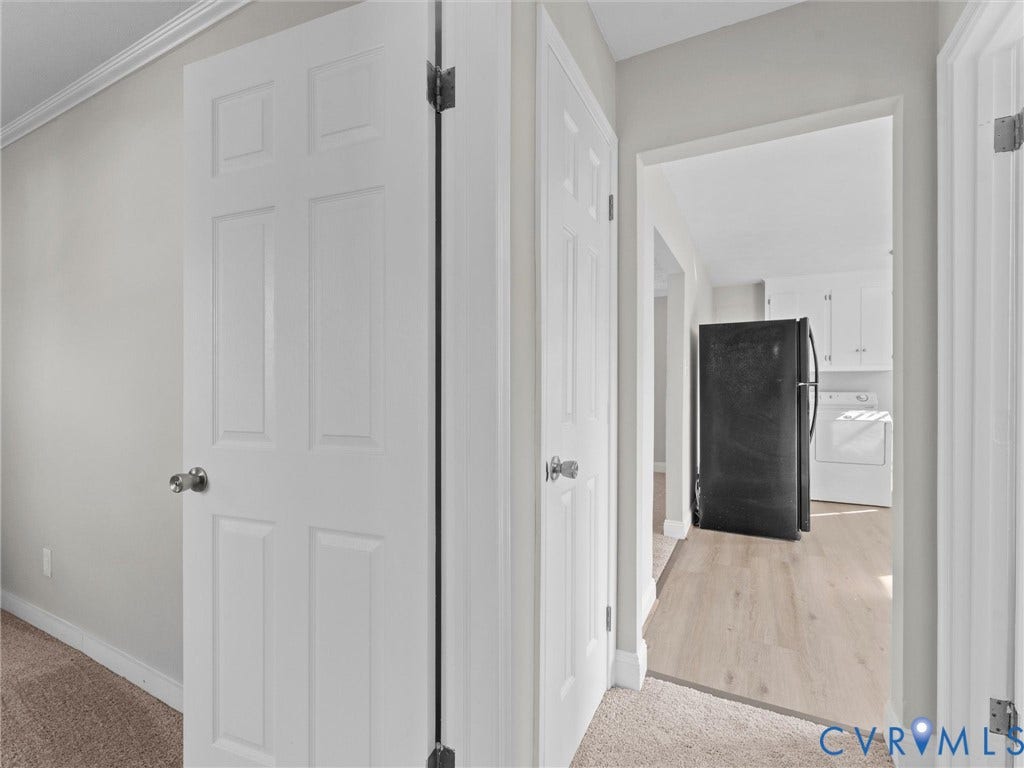 4818 Castlewood Road, Richmond, VA 23234 Bright hallway showcasing white six-panel closet doors, neutral carpet flooring, and clean white trim throughout