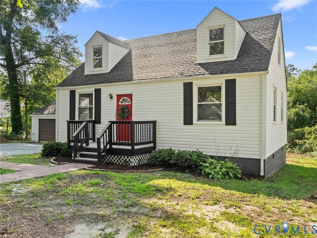 4818 Castlewood Road, Richmond, VA 23234 Classic Cape Cod-style home featuring white horizontal siding, paired dormers with arched windows, and a charcoal-gray asphalt shingle roof