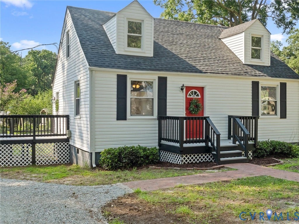 4818 Castlewood Road, Richmond, VA 23234 Classic Cape Cod home featuring light gray vinyl siding, pitched rooflines with slate-colored asphalt shingles, and dormer windows