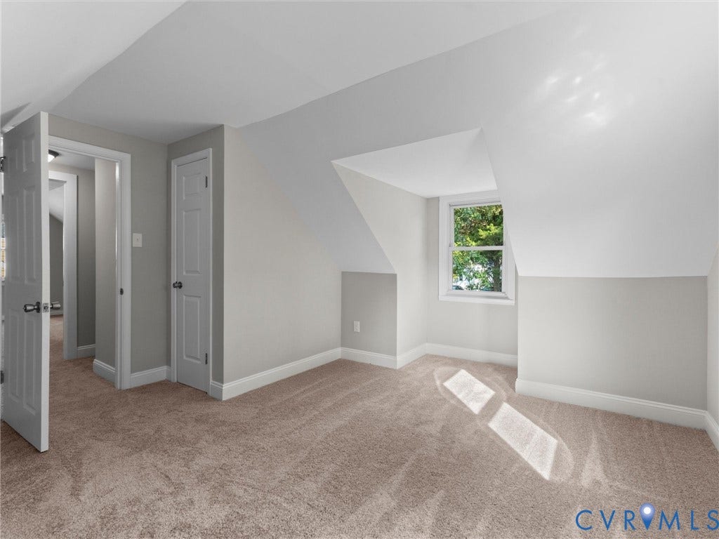 4818 Castlewood Road, Richmond, VA 23234 Bright attic bedroom with sloped ceilings and abundant natural light from a large window
