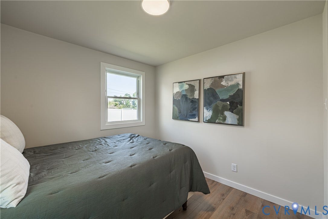 Recessed ceiling light, single window with white trim, wood-finish flooring, and light neutral wall color