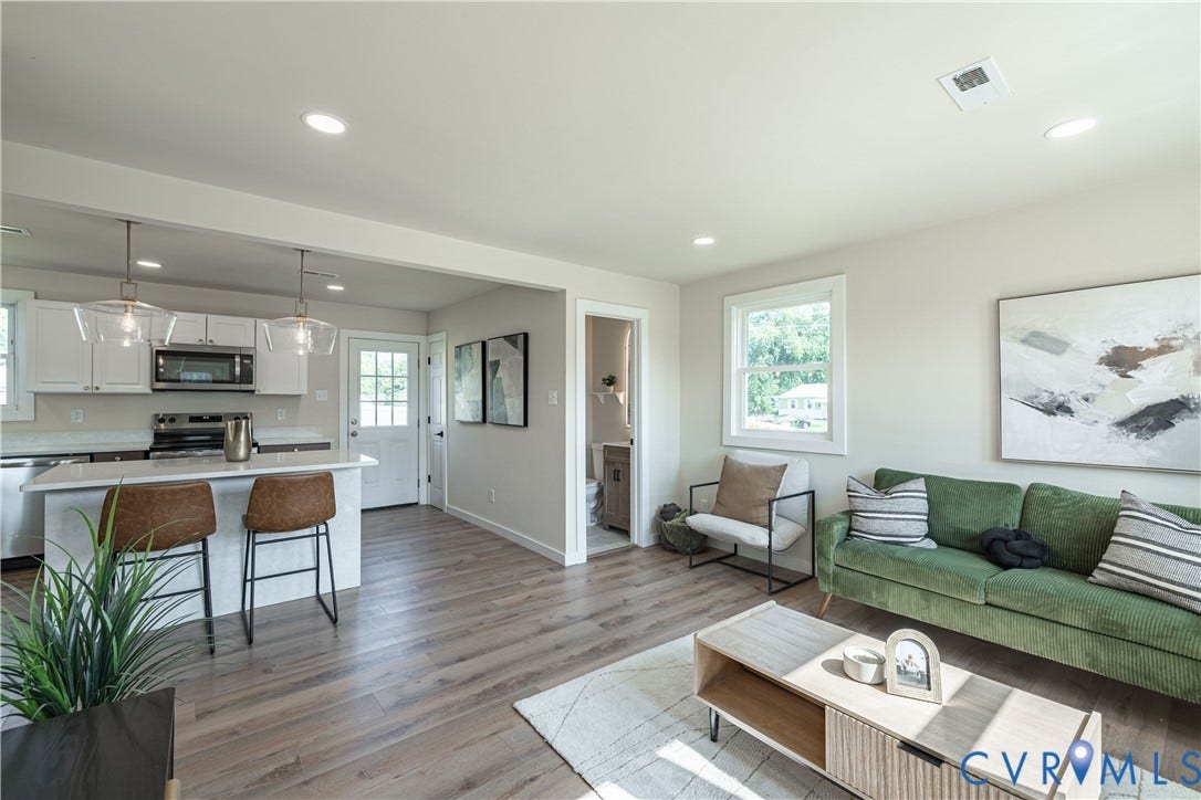 Open-concept living area featuring wood-finish flooring, recessed lighting, and a kitchen island with pendant lighting