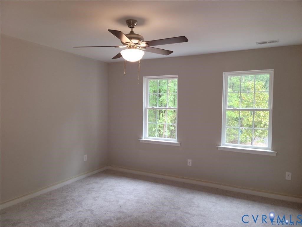 Lot 313 Shenandoah Crossing Drive, Gordonsville, VA 22942 Soft gray wall paint, two bright windows, neutral carpet flooring, and a ceiling fan with integrated lighting
