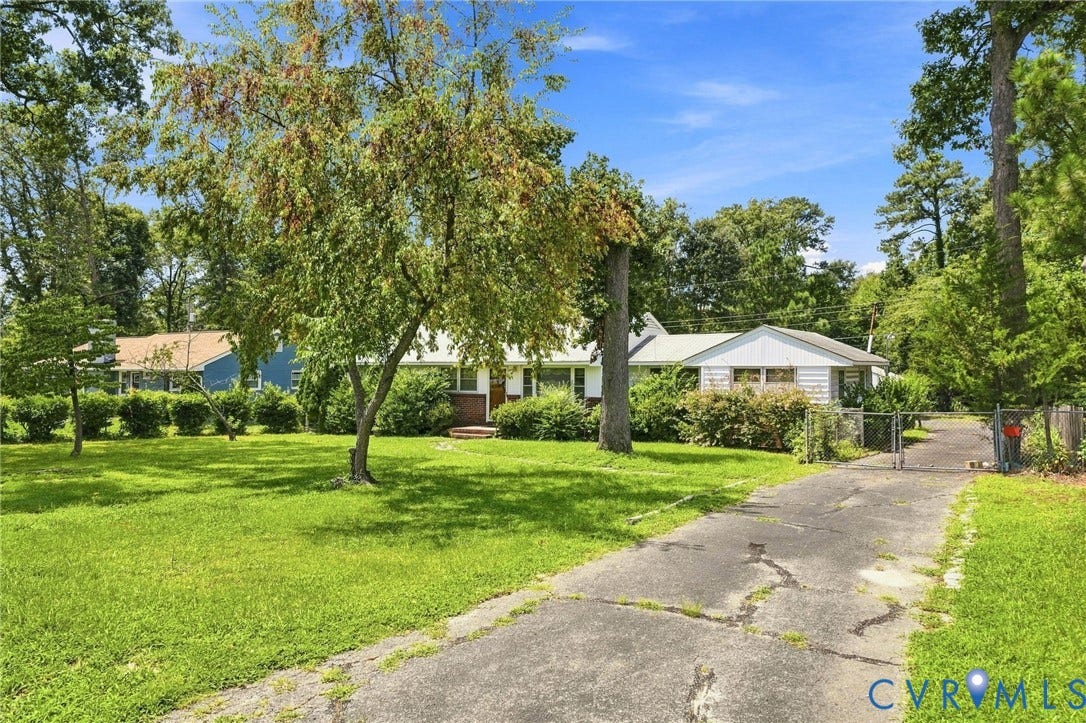 1904 Fon Du Lac Road, Henrico, VA 23229 Expansive lawn with mature trees, driveway leading to a gated entry, and a single-story residence with a white exterior