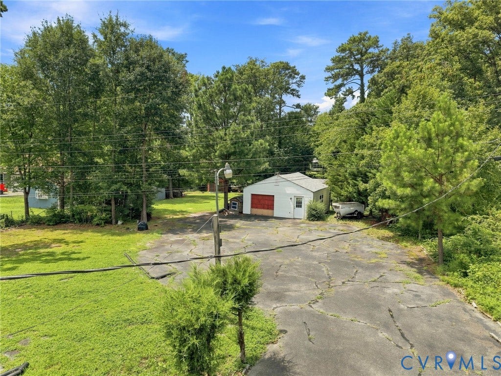 1904 Fon Du Lac Road, Henrico, VA 23229 Detached garage with red door, expansive paved area, and mature trees