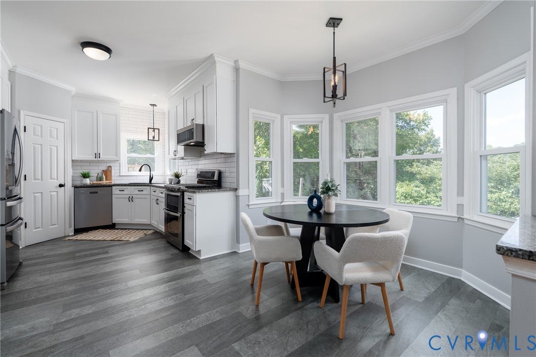 White shaker cabinetry with black hardware, stainless steel appliances, granite countertops, subway tile backsplash, and wood-finish flooring