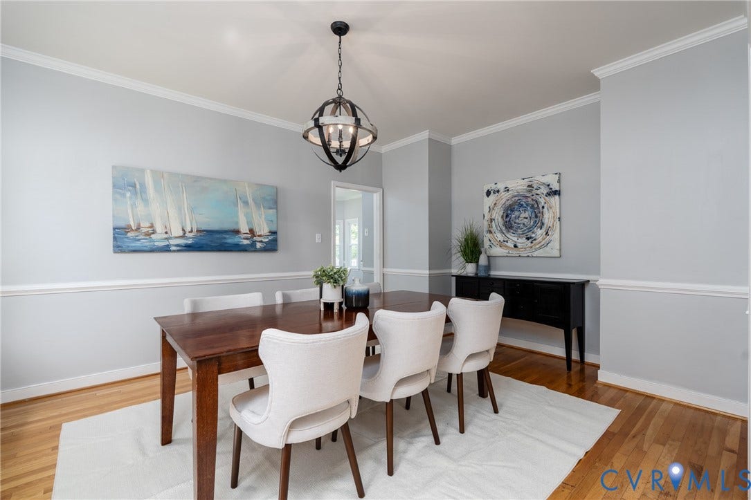 Hardwood flooring, crown molding, chair rail molding, and a spherical chandelier