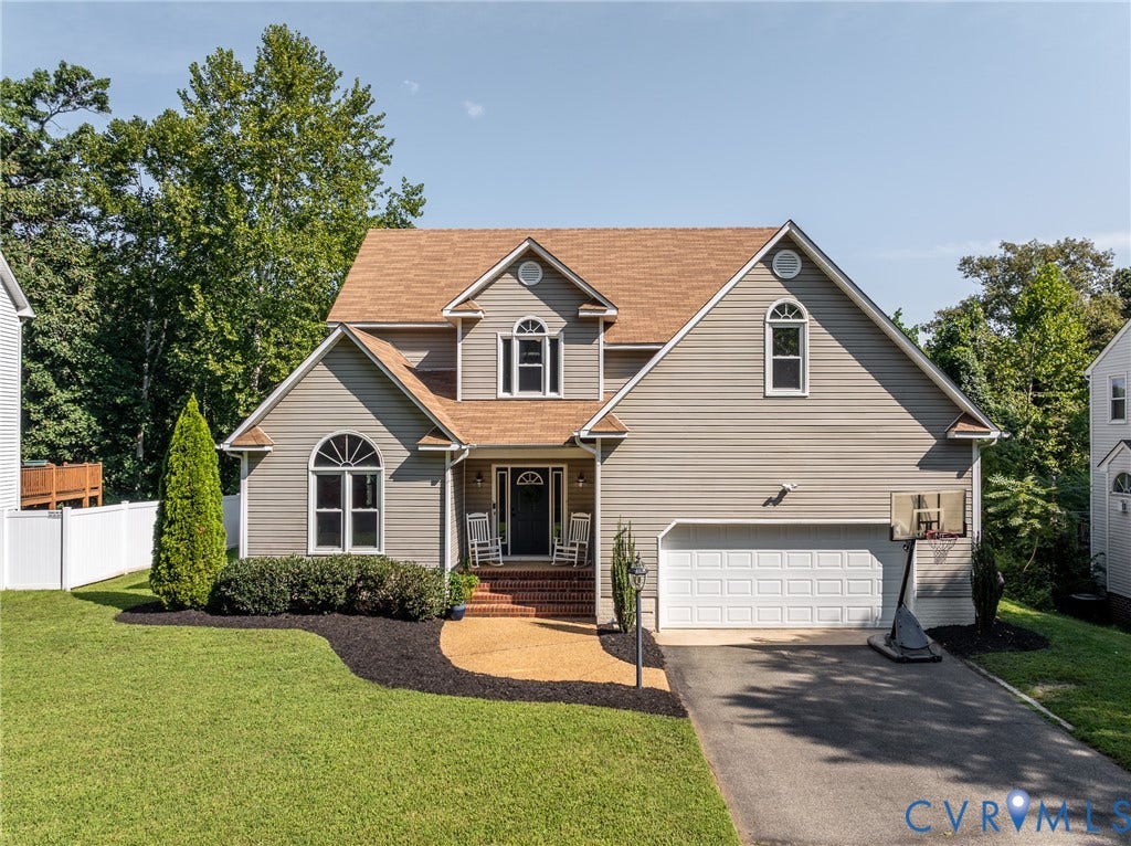 Two-story Colonial featuring a composite shingle roof with multiple gables, vinyl siding exterior, and a covered front entry with decorative columns
