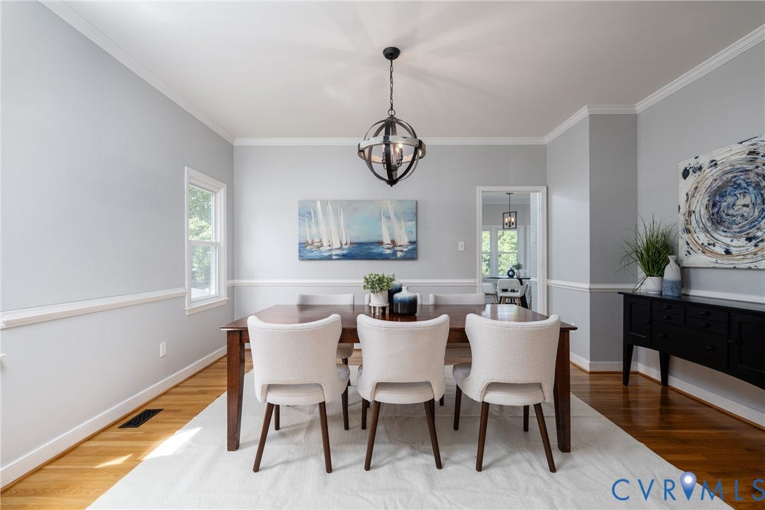 Hardwood flooring, crown molding, chair rail molding, and a spherical chandelier