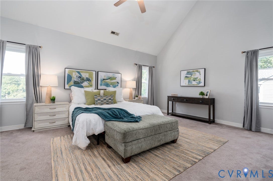 Vaulted ceiling, ceiling fan, and carpeted flooring