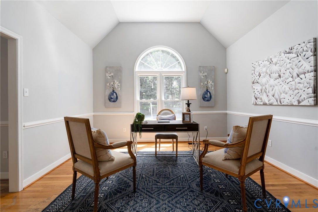 Vaulted ceiling, hardwood flooring, arched window, chair rail molding, and a built-in desktop