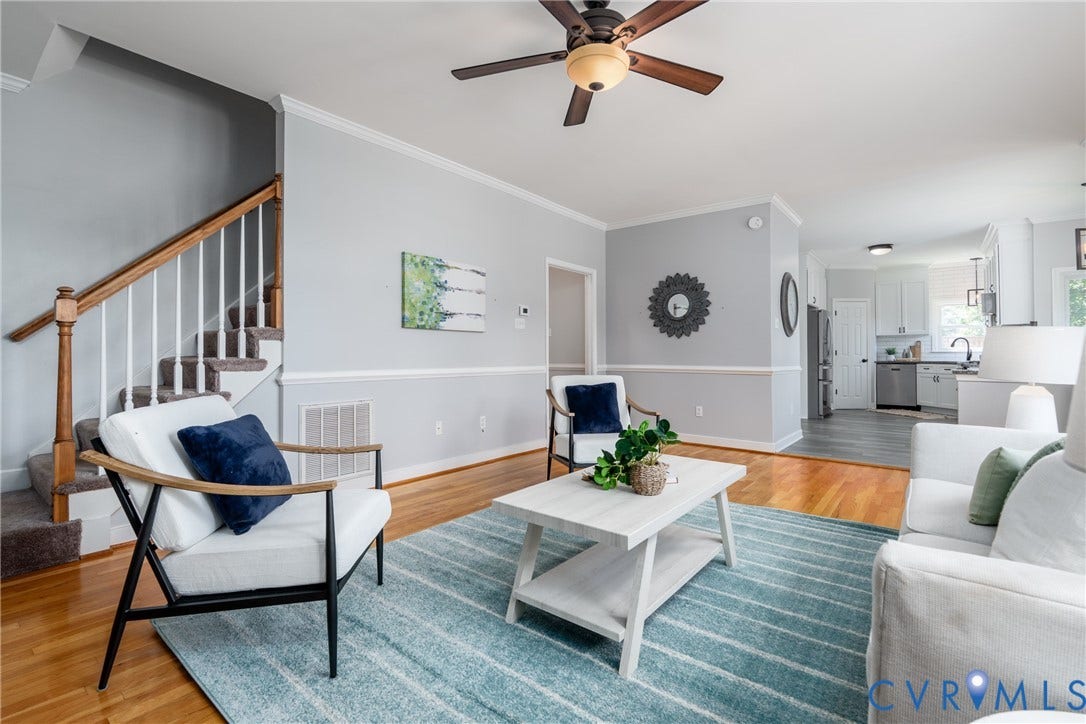 Hardwood flooring, crown molding, chair rail molding, ceiling fan, and staircase with wood handrail